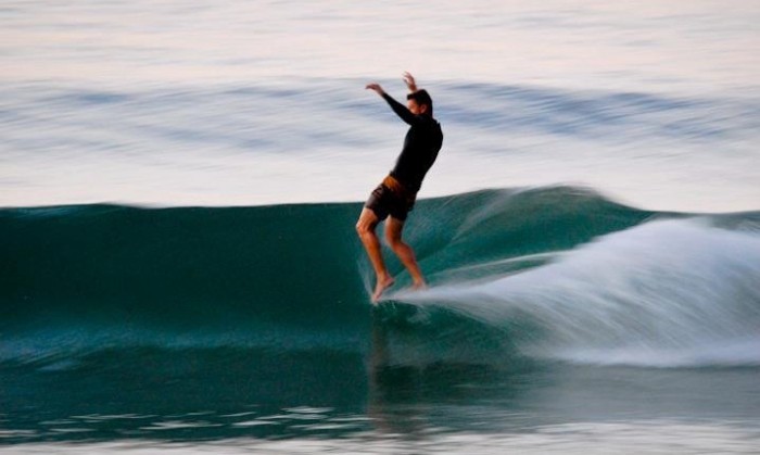 Surfista realizando la maniobra Nose riding